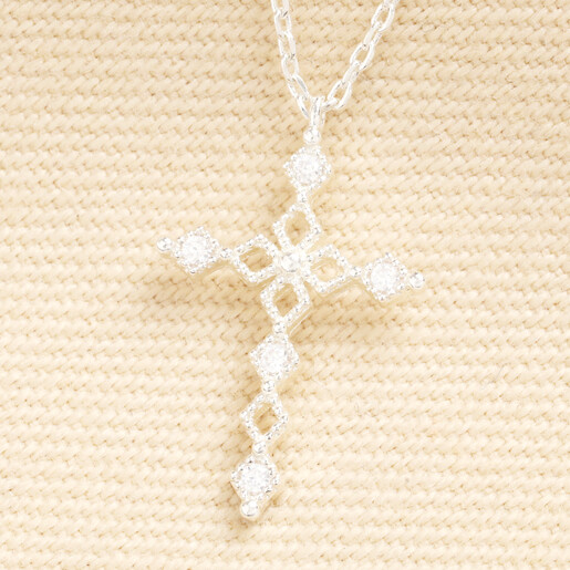 Close-up of the silver crystal cross pendant with intricate cut-out detailing