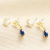 Set of 2 gold earrings with crystal crescent moon studs and blue teardrop drop charms.