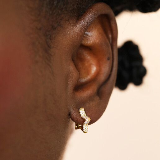 model shot of huggie hoop earrings with celestial design