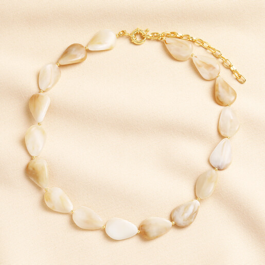 Cream resin stone chunky beaded necklace laid flat on neutral linen fabric