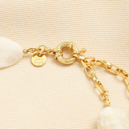 Close-up of gold clasp and Lisa Angel branded charm on cream necklace