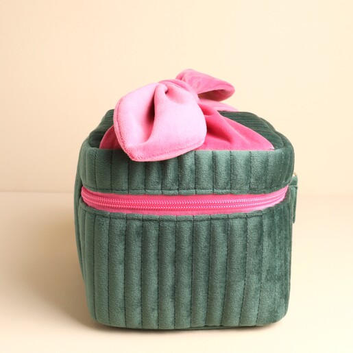 Side view of the structured green ribbed velvet makeup bag with pink zipper