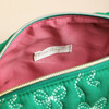 Interior of the green makeup bag showing the pink lining and label