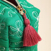Close-up of the gold-tone zip pull and dark red tassel