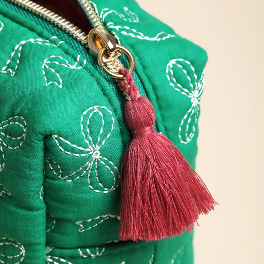 Close-up of the gold-tone zip pull and dark red tassel