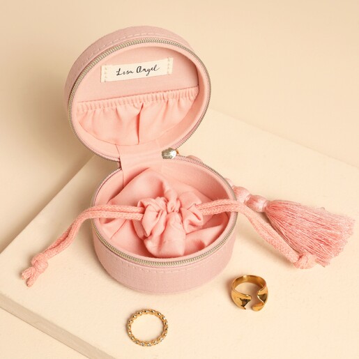 Open pink jewellery case showing drawstring pouch, elastic pocket, and gold rings.