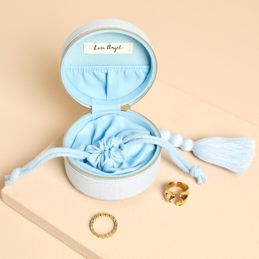 Open blue travel jewellery case revealing drawstring pouch and gold rings.
