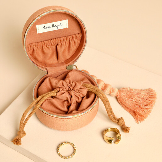 Open jewellery case showing inner drawstring pouch, lid pocket, and gold rings