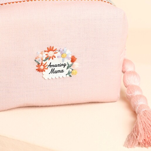 Close-up of the scalloped floral Amazing Mama embroidered patch on pink makeup bag