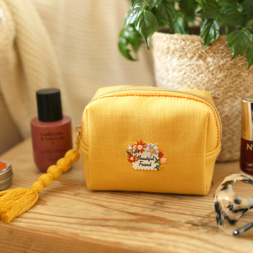 Yellow linen makeup bag with embroidered floral Beautiful Friend motif and beaded tassel