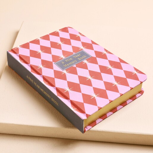 Closed five year memory book displaying gold gilded edges and dark spine