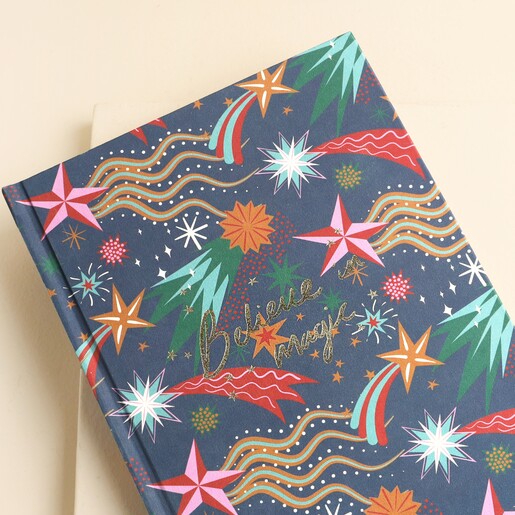 Close-up of shooting star patterned fabric cover and gold glitter Believe in magic script
