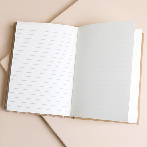 Open striped fabric notebook displaying clean lined white pages