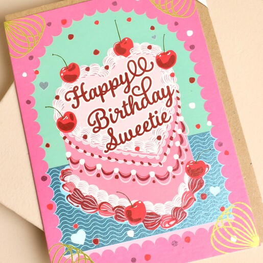 Close-up of retro heart-shaped cherry cake illustration with gold foil details