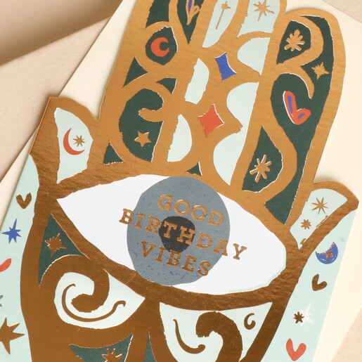 Close-up of die-cut Hamsa birthday card showing gold foil details