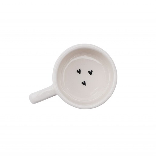Top-down view inside the empty ceramic tealight holder showing three black hearts.