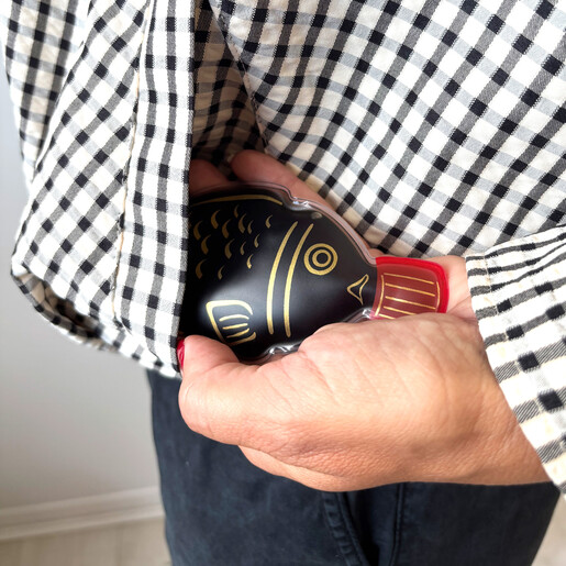 Fish shaped soy sauce hand warmer tucked into a gingham jacket pocket