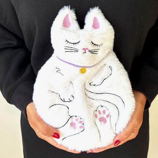 Model holding a plush white sleeping cat hot water bottle with embroidered details