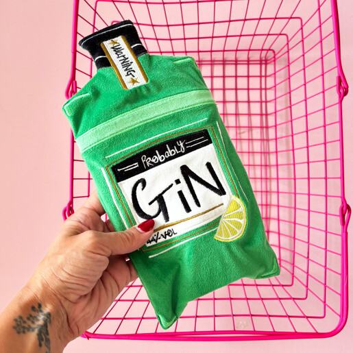 Hand holding the green embroidered gin hot water bottle over a pink basket