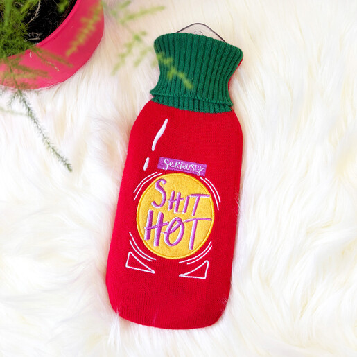 House of Disaster hot sauce bottle hot water bottle on a white faux fur surface