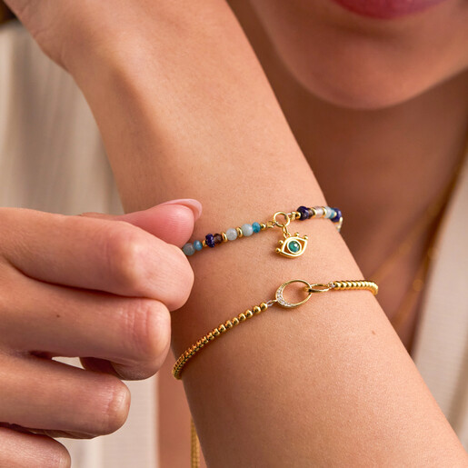 Model wearing the Estella Bartlett evil eye blue beaded bracelet alongside a gold bracelet