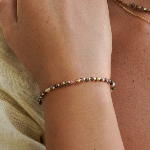 Model wearing delicate multi-coloured tourmaline beaded bracelet on her wrist