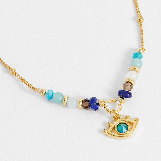 Close up of gold evil eye charm with blue and neutral beads