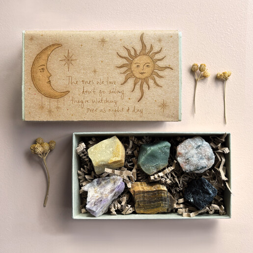Open East of India matchbox gift set displaying six raw crystals nestled in shred.