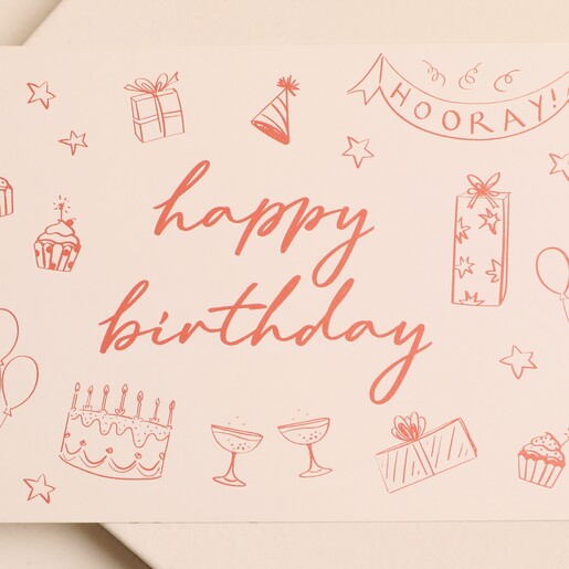 Close-up of the hand-drawn party illustrations and Happy Birthday script on pink notecard
