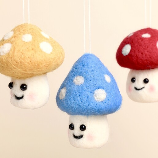 Close-up of three colourful felt toadstool hanging decorations with smiling faces