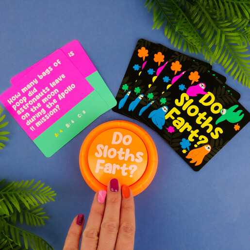Hand pressing the orange buzzer next to Do Sloths Fart trivia playing cards.