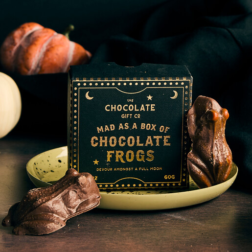 Novelty chocolate frogs displayed alongside a celestial starry gift box on a dish