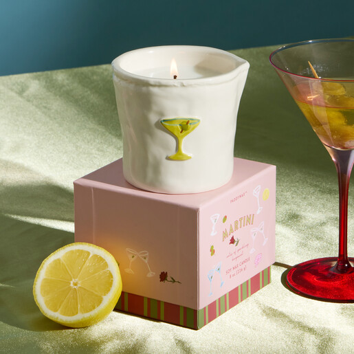 Martini candle lit next to fresh lemon half and cocktail glass