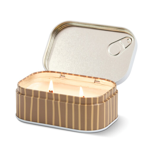 Lit two-wick Paddywax cappuccino soy wax candle inside an open striped metal tin