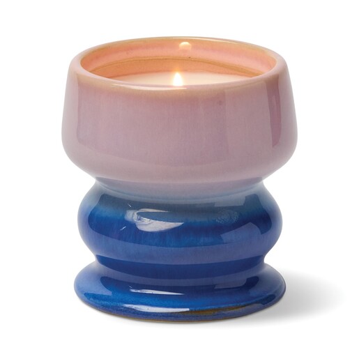 Lit Paddywax scented soy wax candle in a pink and blue ombre ceramic vessel