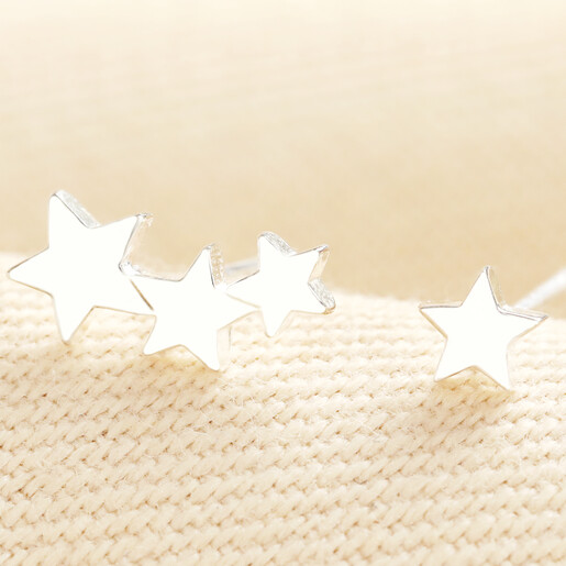 Close up view of silver triple star and single star stud earrings