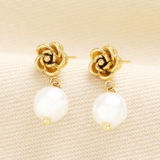Rose gold floral stud earrings featuring luminous pearl drop dangles.