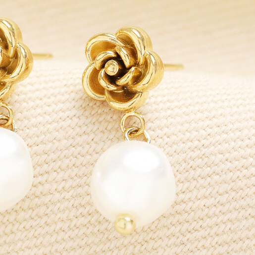 Detailed view of rose gold rose stud with smooth white pearl drop.