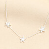 Close up view of the silver plated triple star charm necklace with sparkling crystals.