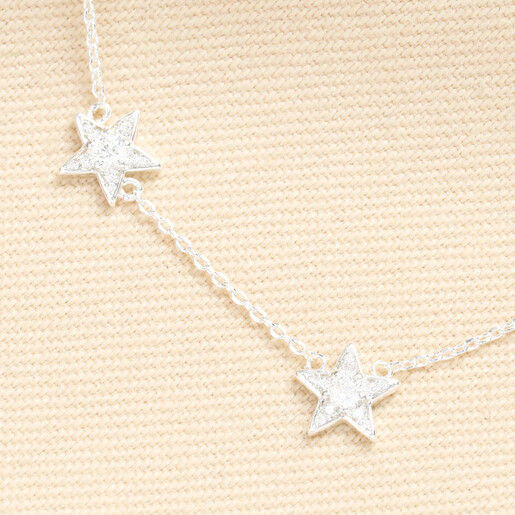 Detailed view of two crystal embellished star pendants on a fine silver chain.