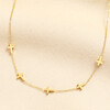 Gold stainless steel chain necklace featuring small cross charms spaced along the fine chain