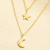 Close up of gold brushed star and crescent moon charms on delicate chains