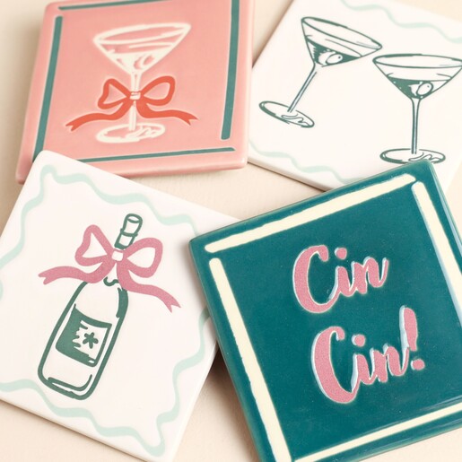 Close-up view of four colourful ceramic drinks coasters with festive illustrations