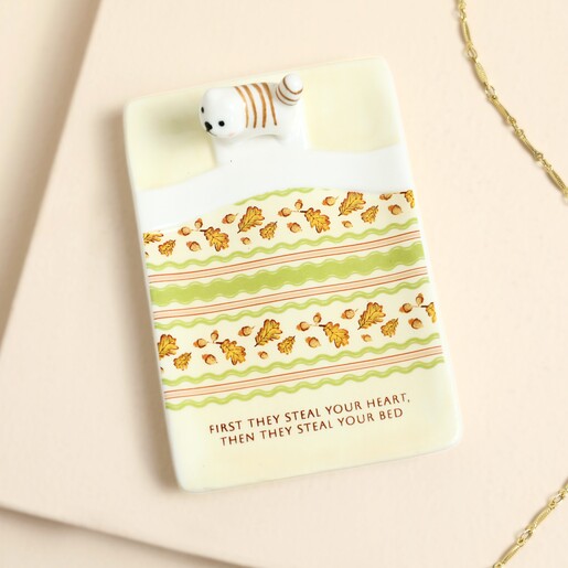 Top-down view of ceramic cat trinket dish with autumn leaf pattern and quote
