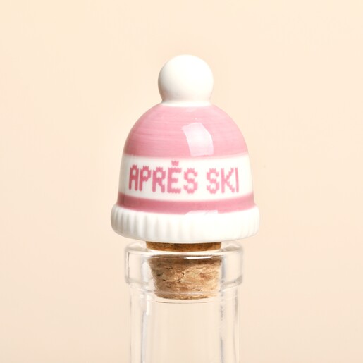 Pink ceramic apres ski bobble hat bottle stopper fitted in a clear glass bottle