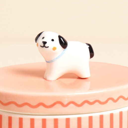 Close-up of sculpted dog topper on pink ceramic lid