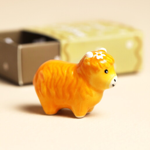 orange ceramic highland cow with flower