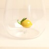 Close up of yellow glass lemon figurine attached to the bottom of tumbler