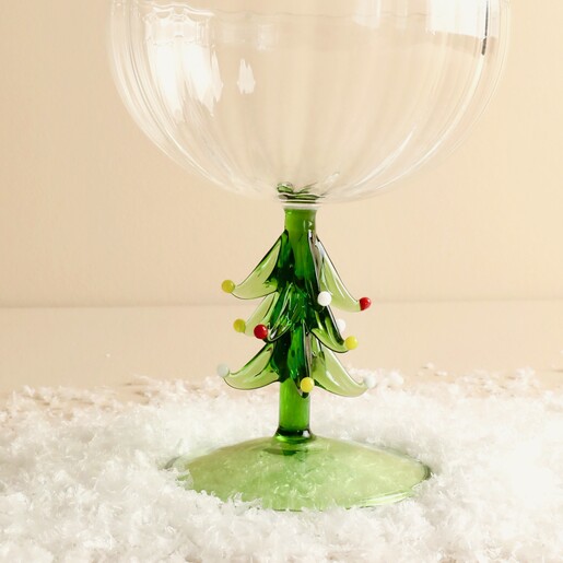 Close-up of sculpted green Christmas tree stem with colourful raised baubles on coupe glass