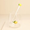 Glass lemon cocktail drink stirrer standing inside a clear glass tumbler with lemon detail